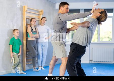 L'uomo in palestra esegue elementi di base del sistema di autodifesa krav maga. Foto Stock