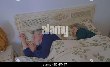 La coppia senior dorme tranquillamente insieme a letto Foto Stock