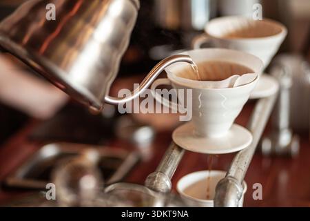 Bollitore che versa acqua su caffè speciale nel filtro v60 Foto Stock