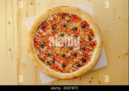 PIZZA ITALIANA CON PROSCIUTTO DI OLIVE E SALSA Foto Stock