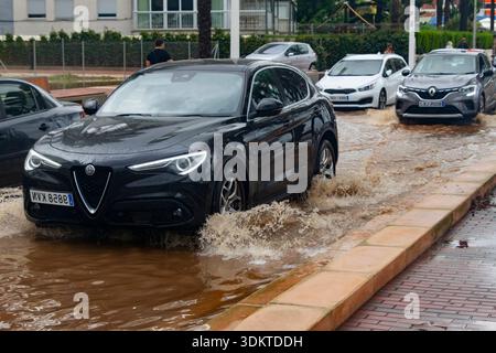 Strade urbane inondate di acqua che trabocca dagli scarichi quando le persone liberano le acque alluvionali e i veicoli si spostano attraverso le aree colpite dopo una pioggia intensa. Spagna. Foto Stock