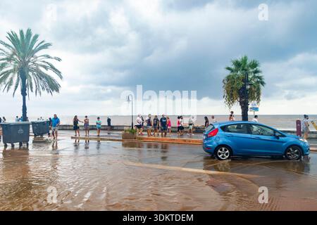 Strade urbane inondate di acqua che trabocca dagli scarichi quando le persone liberano le acque alluvionali e i veicoli si spostano attraverso le aree colpite dopo una pioggia intensa. Spagna. Foto Stock