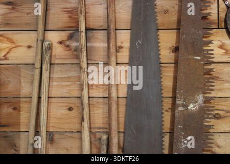 Utensili a mano vintage appesi su una parete in legno dell'officina Foto Stock