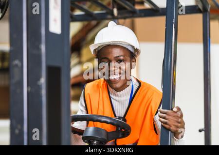 Donna afroamericana che gestisce un carrello elevatore in magazzino Foto Stock