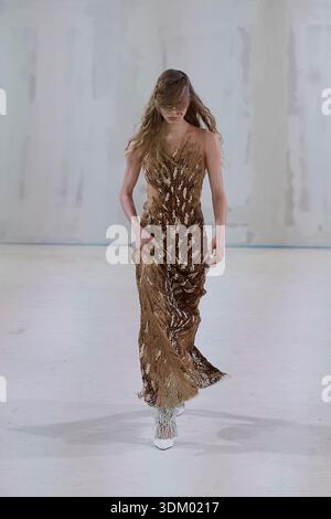 Berlino, Germania, 2 febbraio 2026. Un modello cammina su una pista bianca minimalista che mostra un look all'avanguardia durante la presentazione di Kasia Kucharska Autunno/Inverno 2026 (AW26). L'outfit è caratterizzato da un abito a tutta lunghezza aderente con delicati cinturini sottili, completamente rivestito da un motivo metallizzato astratto marrone e oro testurizzato. Il tessuto drappa elegantemente fino alle caviglie, rivelando un po' esclusivi stivali con tacco alto e un audace design zebra bianco e nero. La parete dello studio industriale grezzo incornicia il design scintillante della collezione. Crediti: Felix Wolf/Alamy Live News Foto Stock