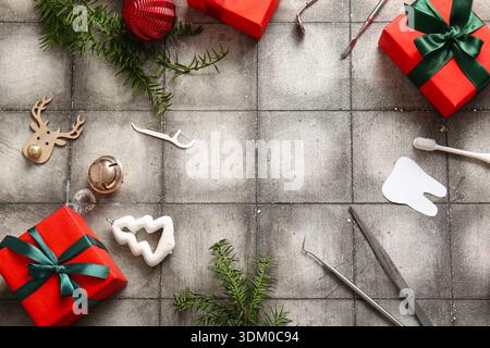 Cornice realizzata con strumenti dentisti, decorazioni natalizie e regali su sfondo grunge Foto Stock
