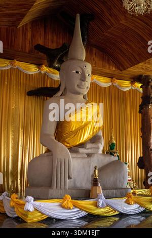Thailandia, Isaan, Sakon Nakhon, Dong Mafai, montagne Phu Pan, Wat Tham Pha Daen, Buddha in contatto con la terra, mudra di Bhumisparsha, posa Foto Stock