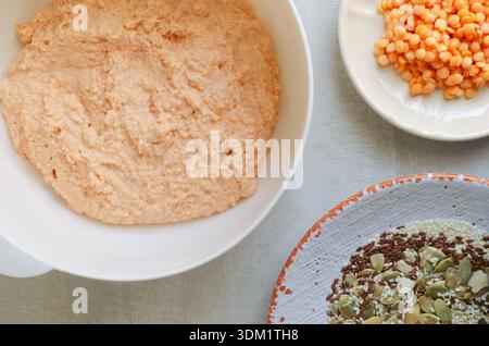 Processo di preparazione dei panini di lenticchie fatti in casa. Lenticchie con farina integrale in un recipiente bianco. Sano concetto di cottura vegan con texture naturali e minimale Foto Stock