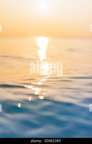 Splendido mare calmo tramonto dorato scintillante riflesso del sole superficie d'acqua ondulata sereno tranquillo paesaggio marino orizzonte da sogno carta da parati calda e bagliore Foto Stock