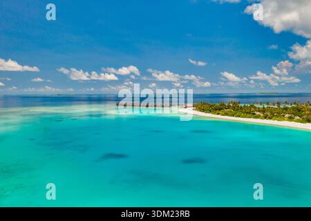 Immersiva isola aerea delle Maldive oceano turchese nuvole radiose paradiso mozzafiato destinazione turistica di lusso costiera splendida carta da parati paesaggistica Foto Stock