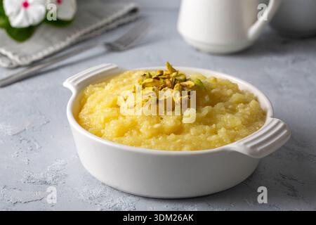 Dolce giallo turco formaggio da dessert halva Hosmerim sul piatto bianco in cucina. Foto Stock