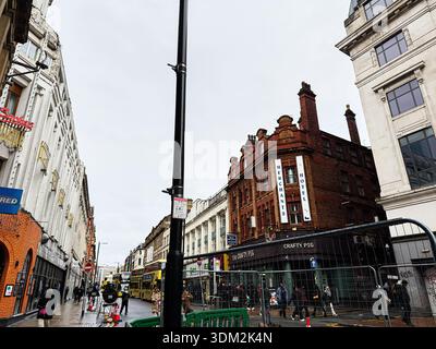 Manchester, Regno Unito - 21 gennaio 2026: Vivace scena di Manchester Street con edifici in mattoni, pedoni e barriere edili. Foto Stock