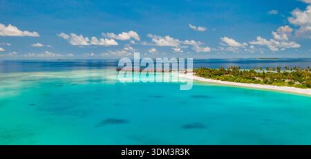 Vista aerea mozzafiato del lussureggiante atollo verde dell'isola delle Maldive, della vivace laguna turchese dell'oceano, del paradiso tropicale incontaminato da sogno, del luminoso grandangolo Foto Stock