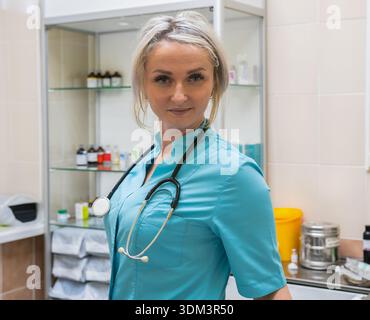 Medico donna che indossa scrub e uno stetoscopio in una clinica medica Foto Stock