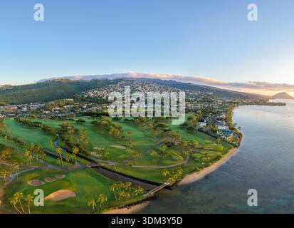 L'alba risplende sul Kahala Hotel and Resort con campo da golf visibile, lussureggianti fairway verdi che conducono verso il Pacifico a Honolulu Hawaii. Foto Stock