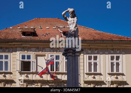 Statua di fronte alle case tradizionali colorate lungo il fiume Lubiana, Lubiana, Slovenia Foto Stock