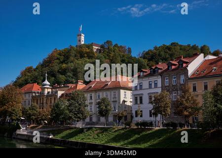 Case tradizionali colorate lungo il fiume Lubiana e il castello sulla collina - Lubiana, Slovenia Foto Stock