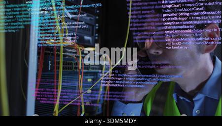 Tenere lo smartphone, il tecnico nel gilet al neon appoggiato verso il server rack con cavi LAN, copiare spazio Foto Stock