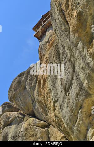 Monastero di Meteora in Grecia costruito sulla formazione rocciosa. Edificio del monastero di Meteora aggrappato a una parete rocciosa a picco su un cielo blu. Foto Stock