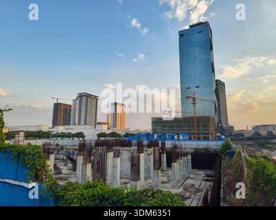 vista di alti edifici e di un cantiere attivo con pilastri e gru in cemento. Phnom Penh, la capitale della Cambogia Foto Stock