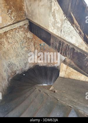Scala a chiocciola, all'interno di le Manolis, un ex hotel in un vecchio edificio coloniale francese, a Phnom Penh, Cambogia. Foto Stock