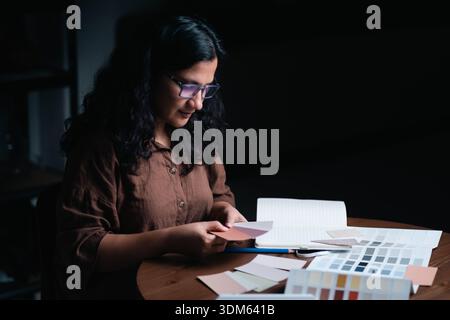Designer d'interni che lavora su un progetto di ristrutturazione di ville presso il banco dell'ufficio a Dubai Foto Stock
