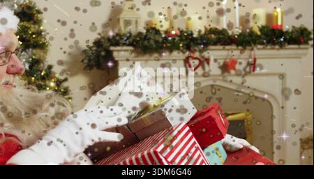 Tenere un uomo in tuta Babbo Natale in equilibrio regali avvolti a casa, con caminetto garland, spazio copia Foto Stock