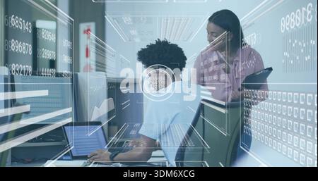 Coppia che collabora indossando una T-shirt azzurra e una blusa rosa chiaro sulla scrivania dell'ufficio, visualizzando l'HUD del laptop Foto Stock