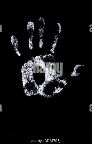immagine ad alto contrasto di un'impronta bianca testurizzata, come se fosse realizzata con vernice o polvere, visualizzata in modo netto su uno sfondo nero pieno. Foto Stock