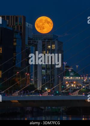 Luna che si innalza sopra l'edificio EXO nei Docklands di Dublino Foto Stock