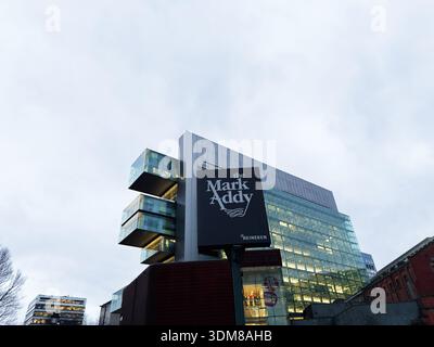 Manchester, Regno Unito - 21 gennaio 2026: Cartello del pub Mark Addy accanto a un edificio in vetro contemporaneo a Manchester, Regno Unito. Foto Stock