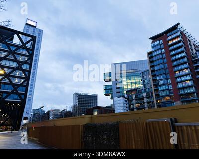 Manchester, Regno Unito - 21 gennaio 2026: Skyline urbano di Manchester con torri di vetro e appartamenti in mattoni al tramonto. Foto Stock