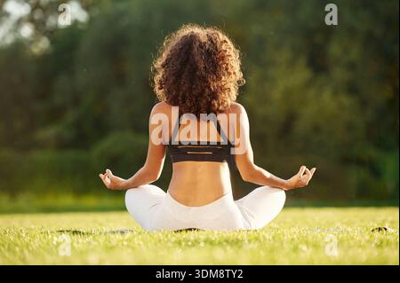 Vista posteriore. Donna sportiva che fa fitness sul campo. Foto Stock