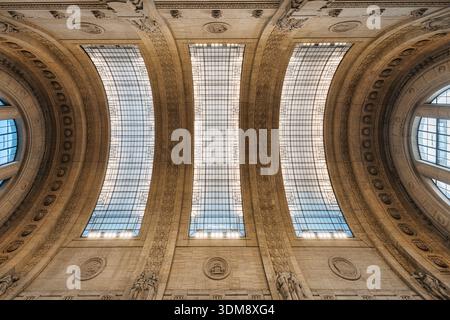Vista verso l'alto dei dettagli interni architettonici del grande soffitto ad arco classico e della pietra scolpita a Milano centrale, Milano, Italia Foto Stock
