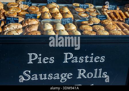 Selezione di torte appena sfornate, pasticceria e pasticceria in mostra alla vetrina di un negozio di torte e panetterie in Shirley High Street, Southampton, Hampshire Foto Stock