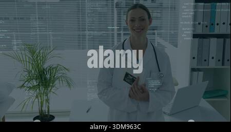 Tenendo gli appunti che mostrano gli ultrasuoni in ufficio medico, indossando camice da laboratorio bianco e stetoscopio Foto Stock