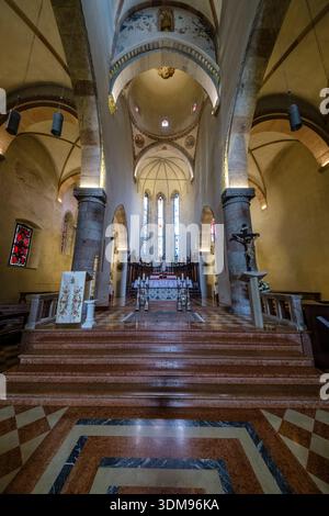 Veduta dell'altare e del coro della chiesa Duomo di Santa Maria Assunta con gradini in pietra, colonne e vetrate colorate in lontananza. Foto Stock