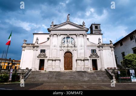 Facciata in pietra e scalini della chiesa di San Michele, Cattedrale dell'Arcangelo sotto un cielo blu a San Daniele del Friuli. Foto Stock