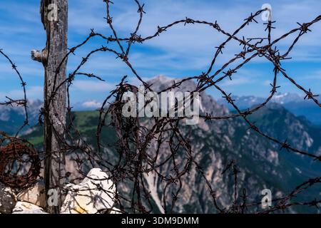 Intrecci di filo spinato arrugginito della prima guerra mondiale sul Monte piana con picchi dolomitici in lontananza. Foto Stock