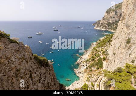 Isola di Capri, Italia - 28 luglio 2021: Vista aerea del litorale roccioso sul Mar Tirreno vicino a Marina piccola, un sacco di barche turistiche a vela Foto Stock
