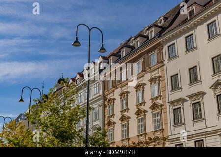 Vienna, Austria: 21 ottobre 2025: Fila di edifici storici con facciate ornate e lampioni nel centro della città Foto Stock