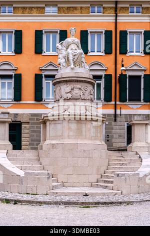 Monumento della Pace, Monumento della Pace in Piazza della Libertà di fronte a un edificio con facciata arancione e persiane verdi. Foto Stock