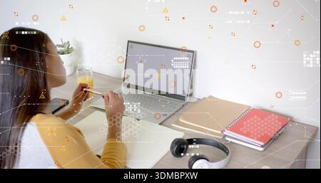 Tenete in mano una matita, un adolescente che indossa la parte superiore gialla che studia alla scrivania, una cuffia per notebook, spazio per le copie Foto Stock