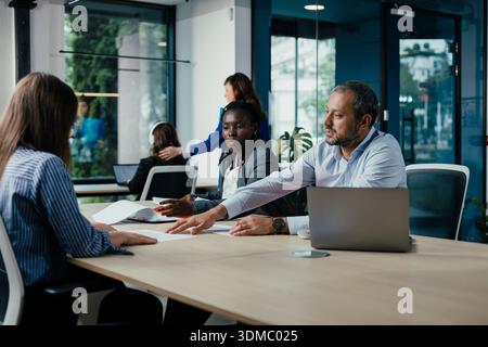 Team aziendali diversificati che collaborano durante una riunione d'ufficio Foto Stock