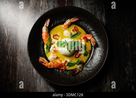 Un piatto di cibo con gamberi e riso. I gamberetti sono disposti in cerchio intorno al riso Foto Stock