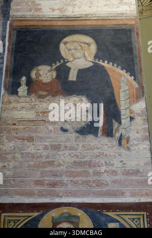 Affresco della Madonna con bambino nella Basilica di San Lorenzo maggiore (Basilica di San Lorenzo), Milano, Italia. Pittura murale religiosa medievale su mattoni. Foto Stock