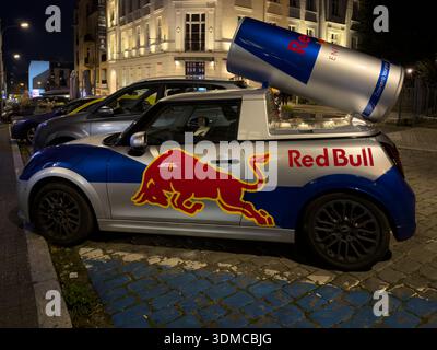 Poznan, Polonia - 18 novembre 2025: La speciale Mini Cooper di Red Bull, con un'enorme replica di lattine, cattura gli occhi sulla strada della città di notte, aumentando il presen del marchio Foto Stock