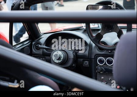 Un primo piano dell'abitacolo interno di una classica auto NB. La vettura sportiva JDM è stata modificata con un volante a sgancio rapido e una barra antirollio specifica per le gare. Foto Stock