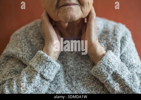 Senior donna che soffrono di dolore al collo Foto Stock