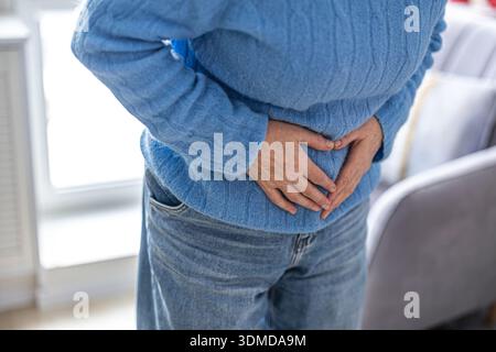 Donna matura che soffre di dolore addominale Foto Stock